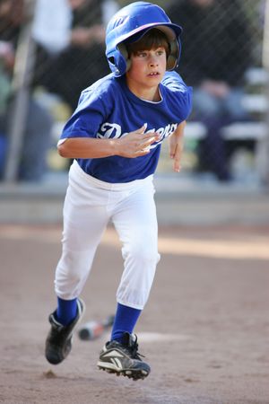 Little league player in Dodgers uniform running between bases.