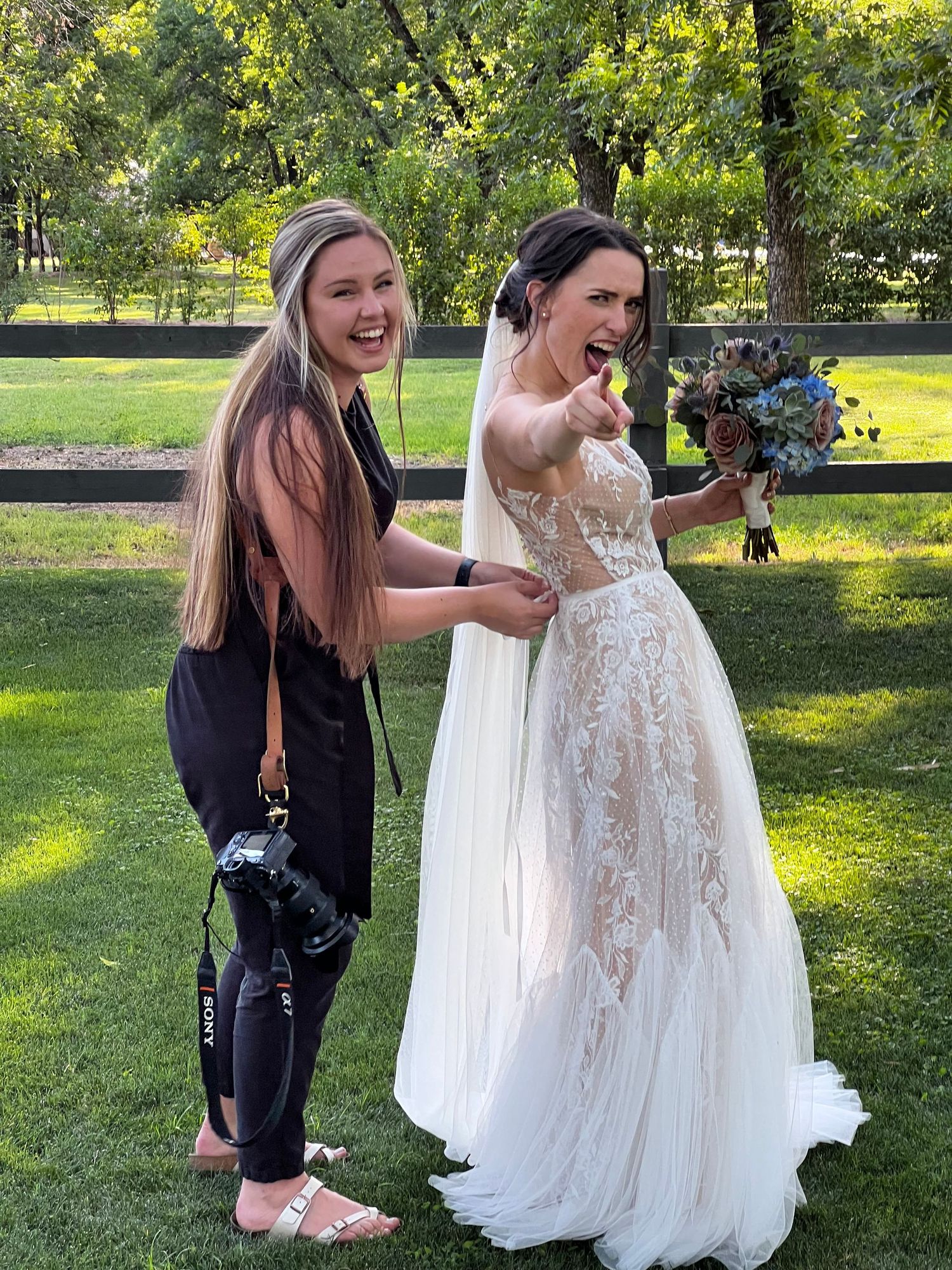 Arizona Wedding Photographer in action, helping a bride fasten her wedding dress