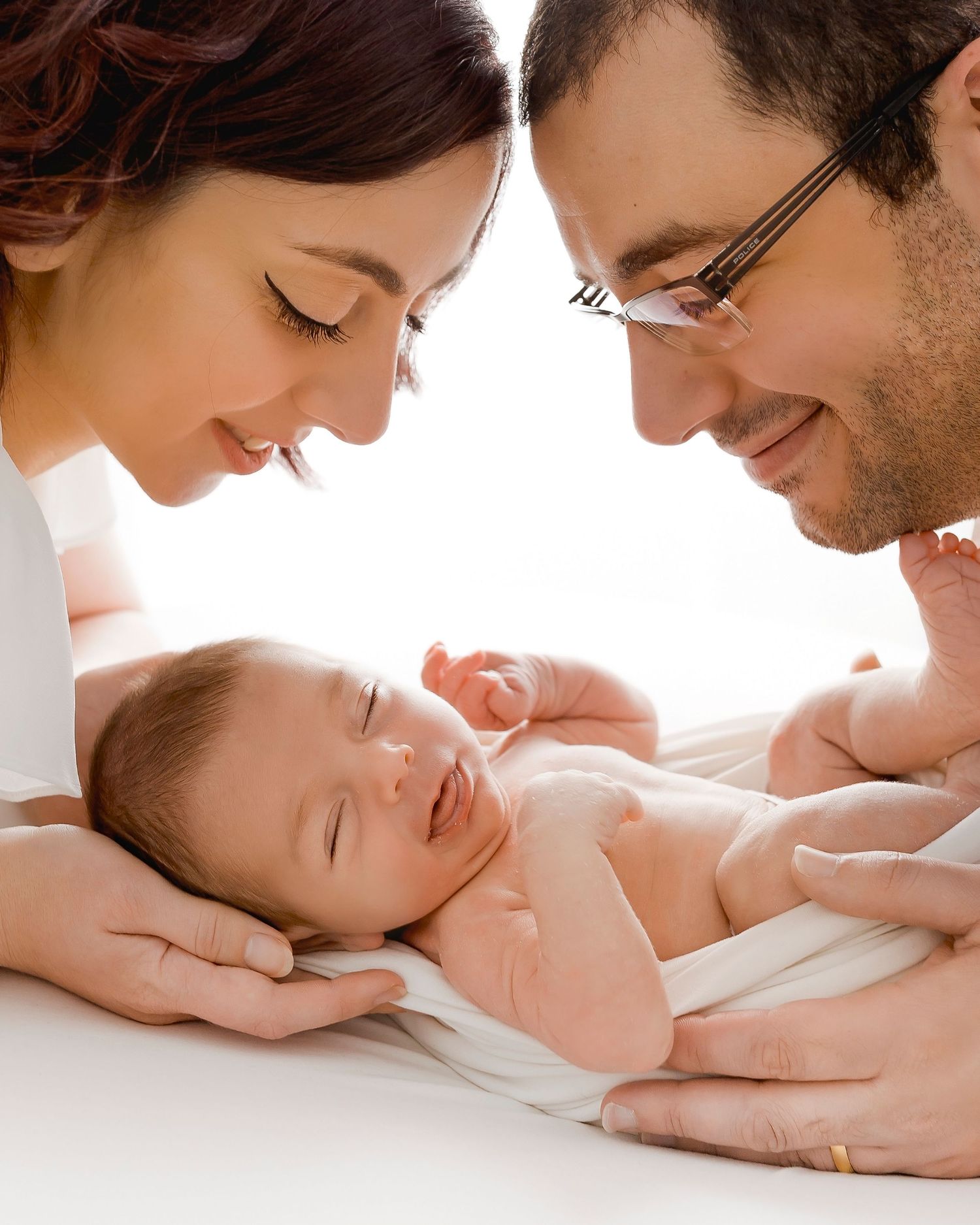 Tender family moment with newborn baby on white background.