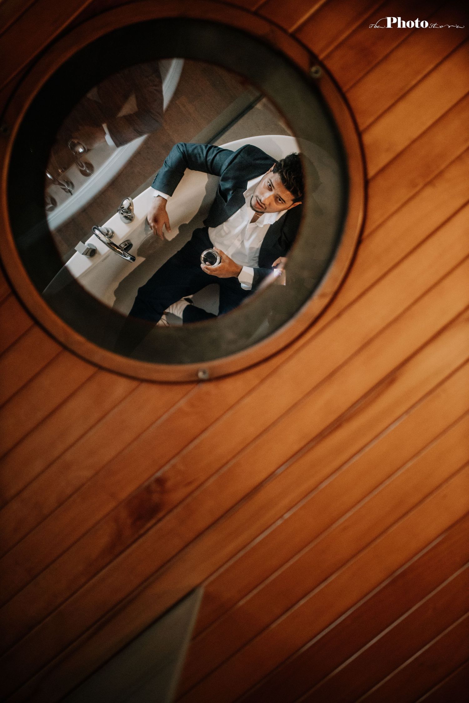 Looking down at wooden floorboards with circular porthole-style windows creating dramatic lighting patterns.