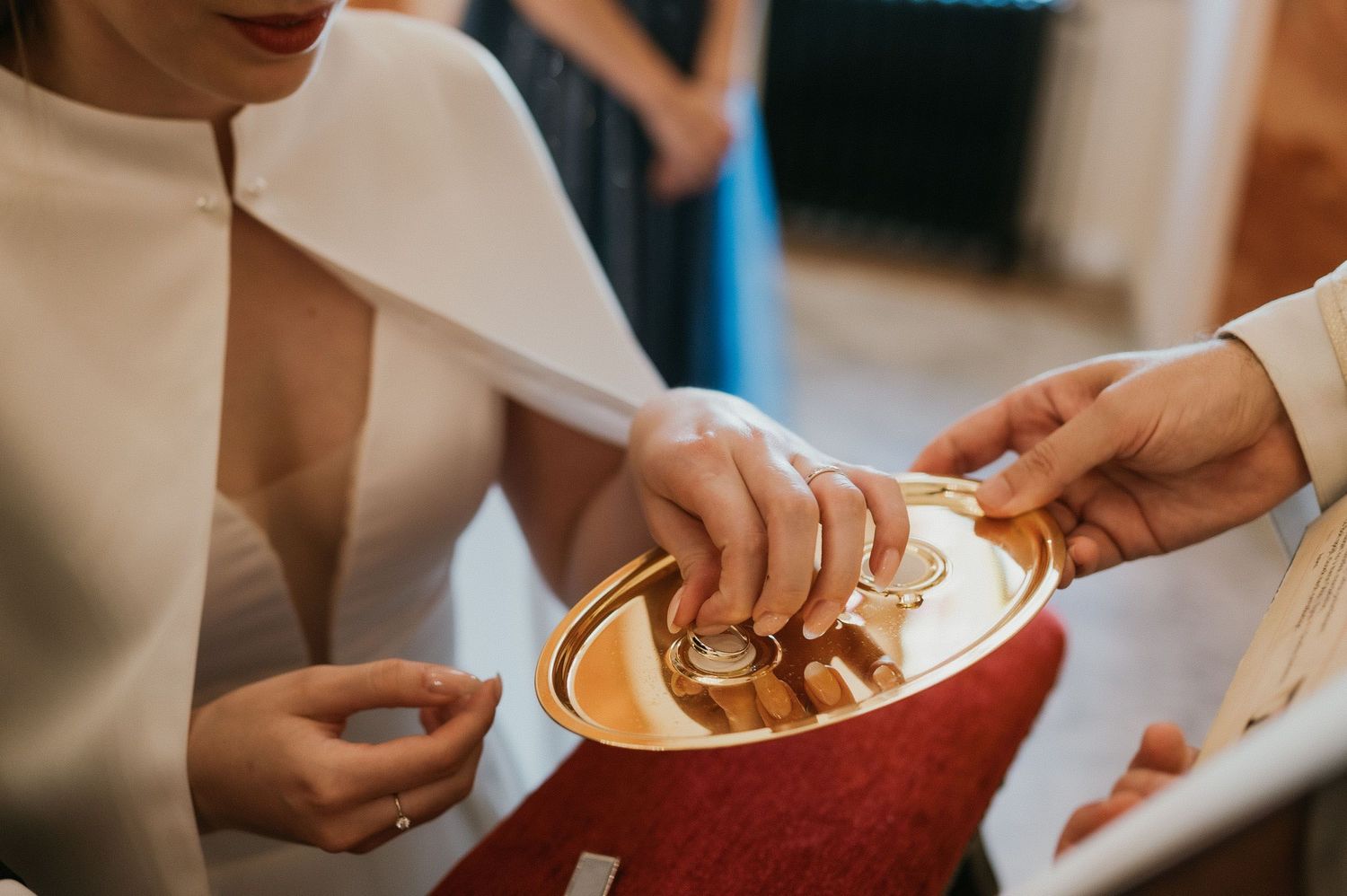 Close-up shot of hands exchanging rings during a religious wedding ceremony.