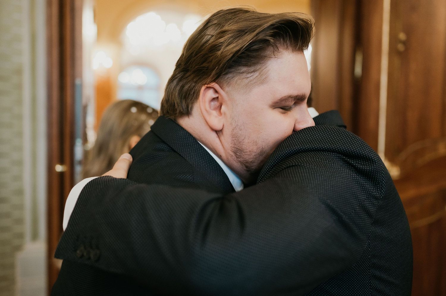 Two people sharing an emotional embrace at a formal event.