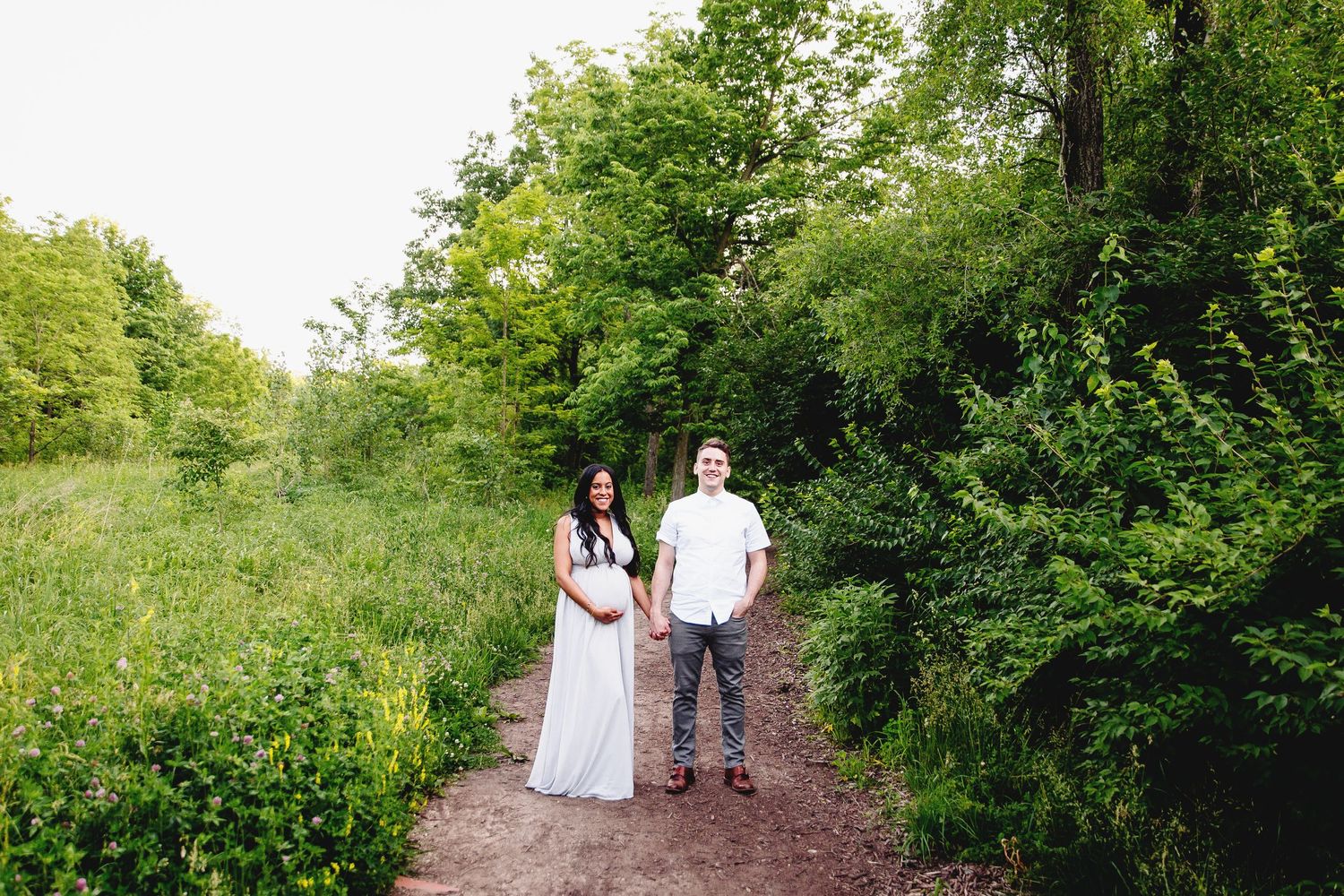 couple posed on walking path for maternity photoshoot by kansas city maternity photographer
