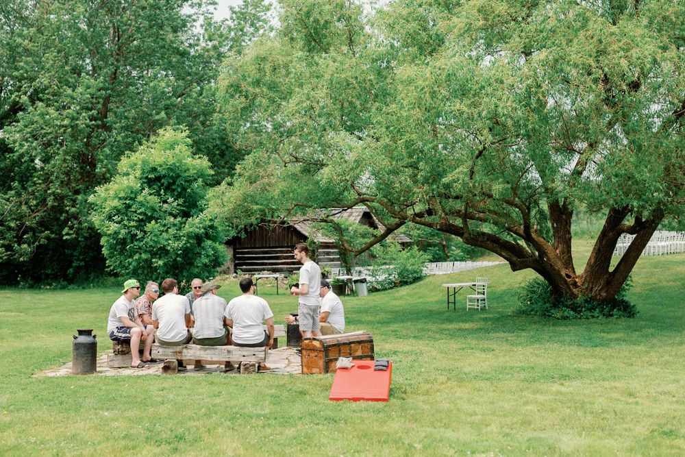 Outdoor wedding venue setup with vintage furniture and decor in a lush garden setting.