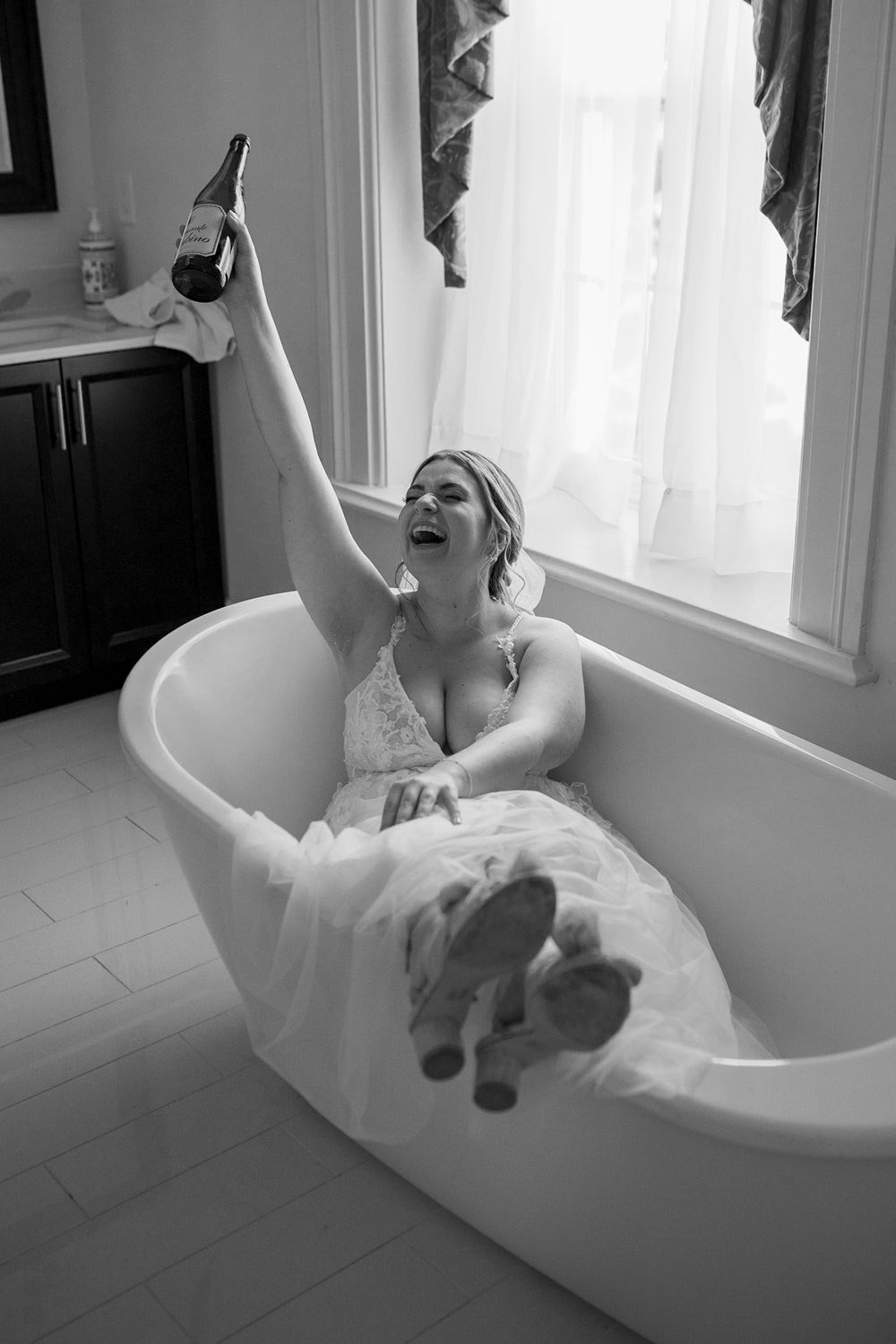 Playful bridal portrait session in a vintage clawfoot bathtub.