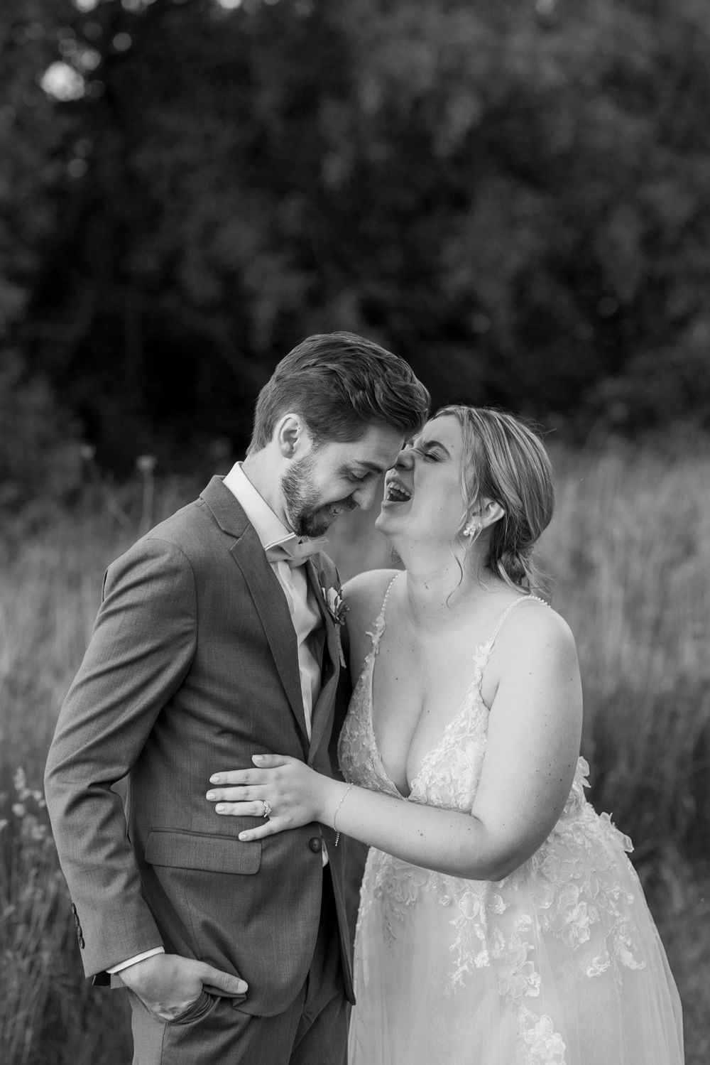 Romantic black and white wedding portraits captured in a field at golden hour.