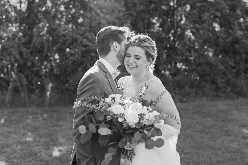 Romantic wedding portraits captured in a natural outdoor setting with floral bouquet.