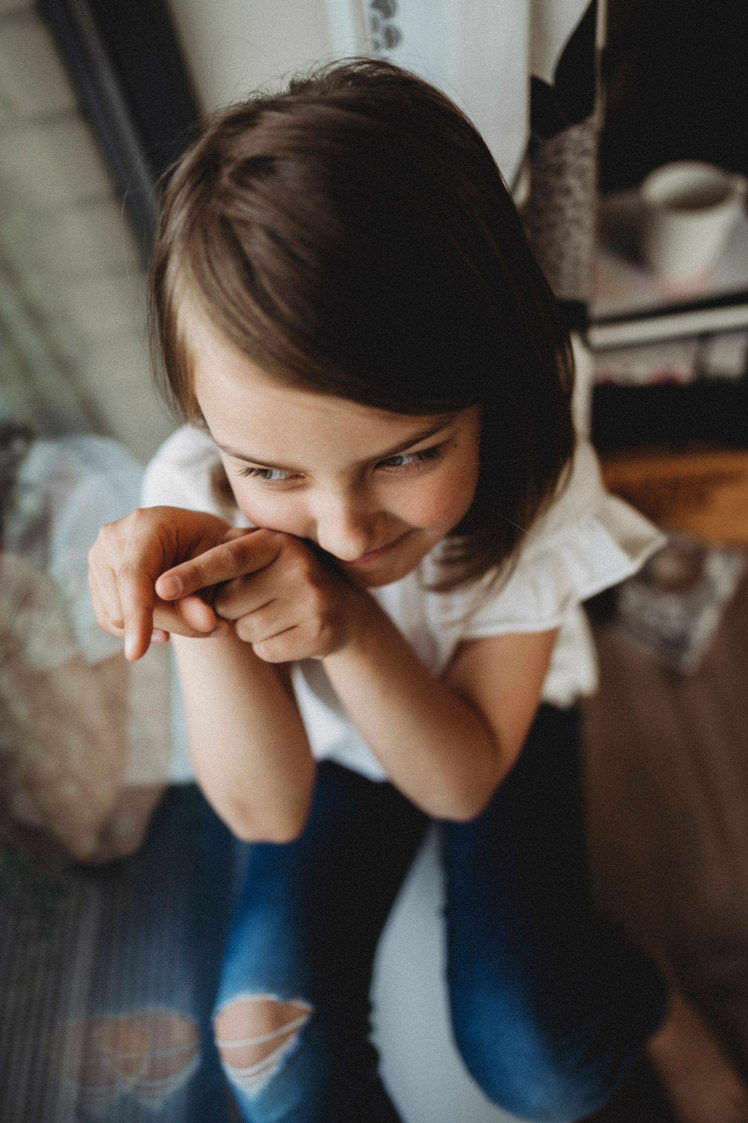 An intimate indoor portrait showing joy and laughter in natural window light.
