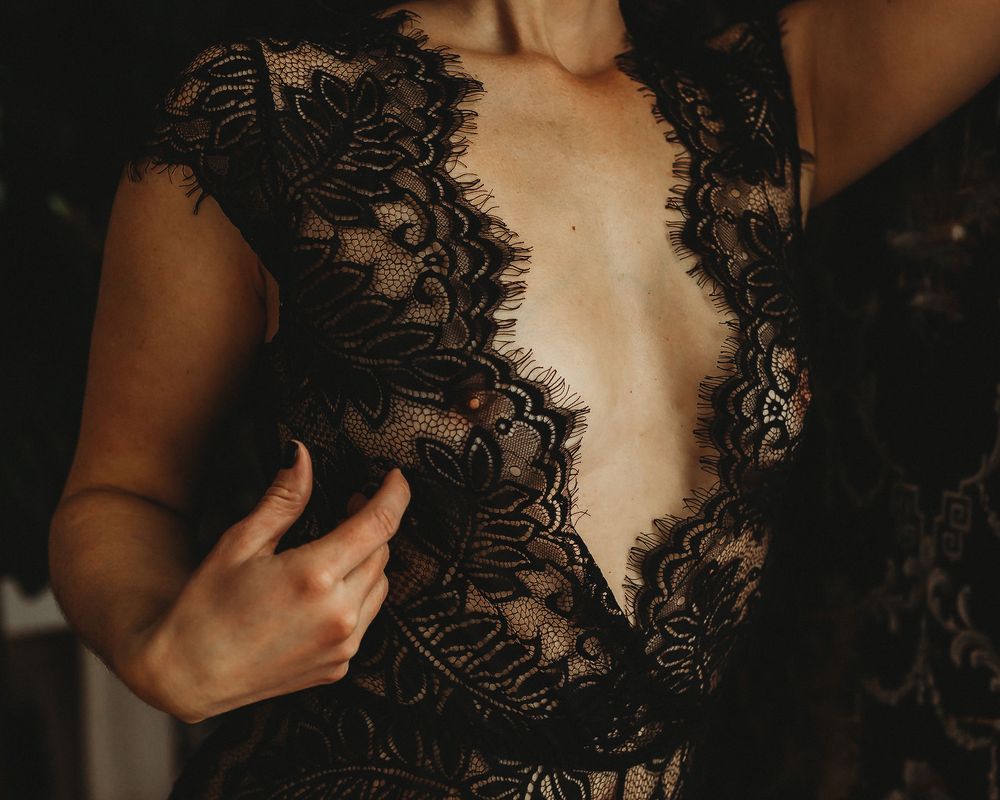 Close-up shot of black lace bodysuit with intricate detail.