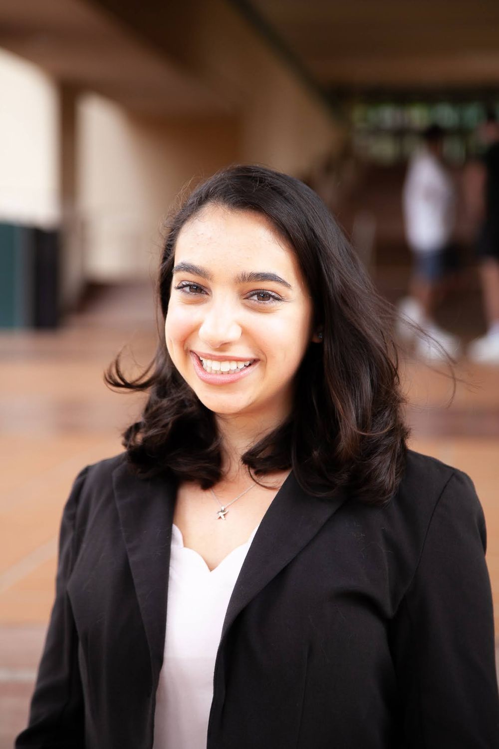 Young professional woman smiling by hallway.