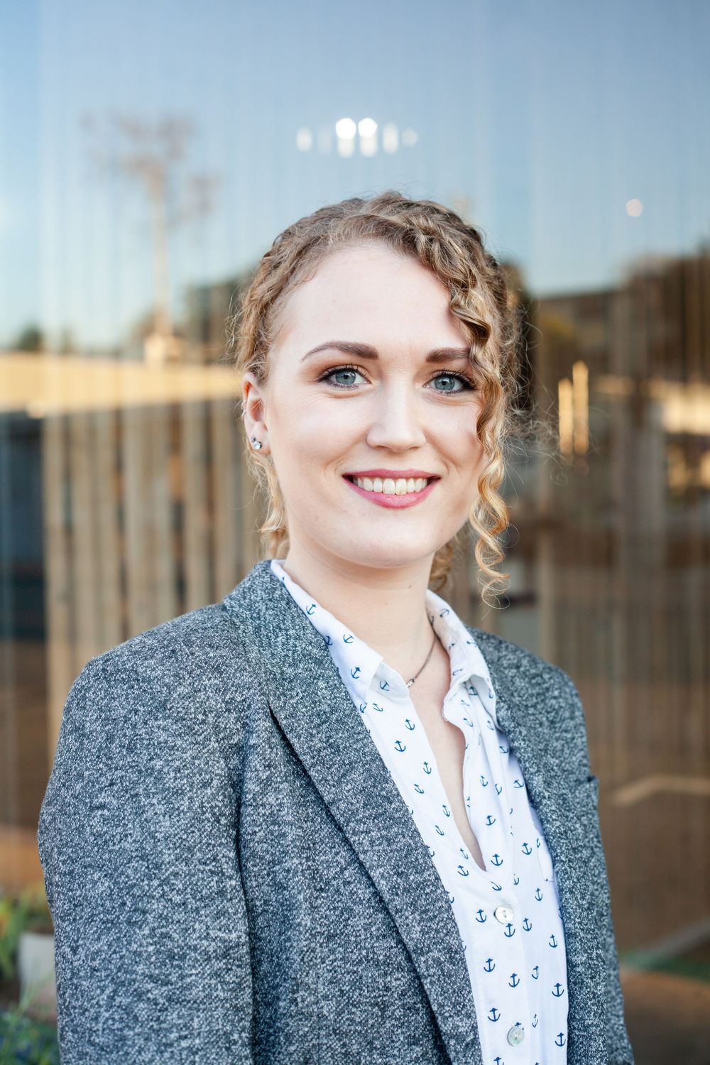 Young professional woman smiling by window.
