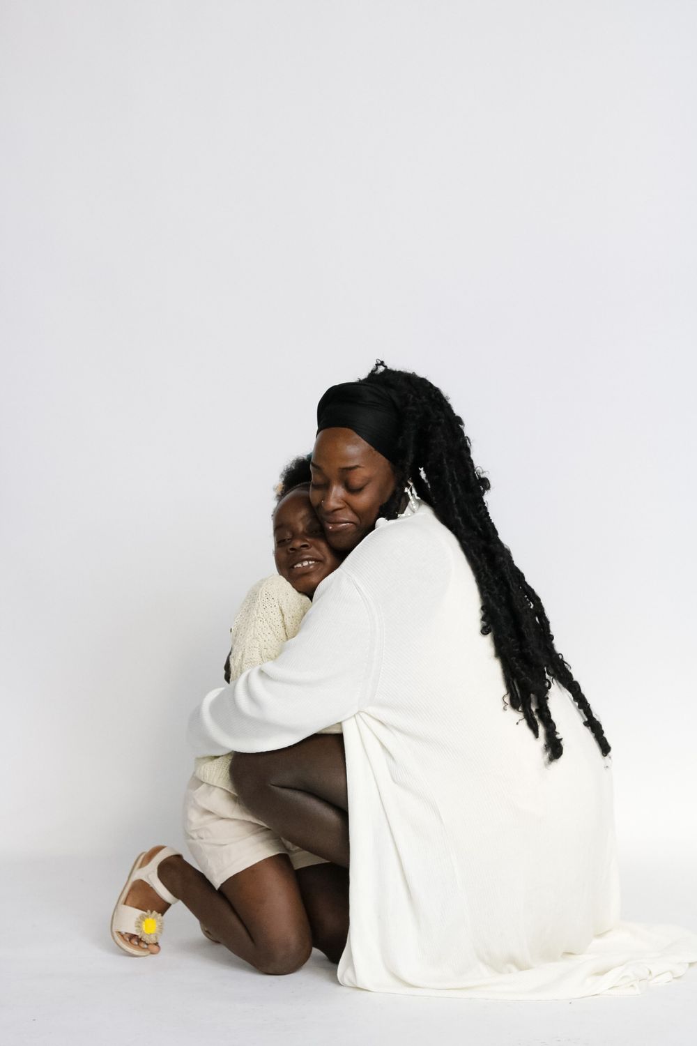 Intimate family portrait in white and cream tones showing tender moments.