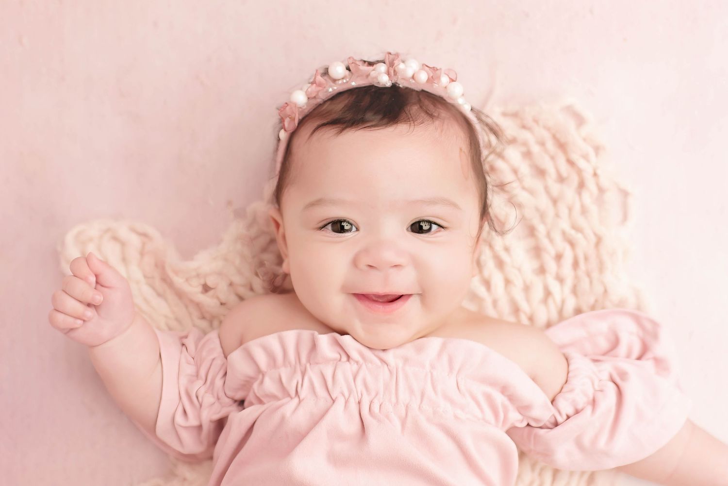6 month milestone little girl in pink with pink backdrop