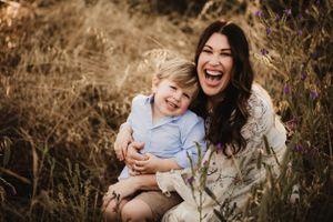 Candid laughter and embraces shared between family members in natural setting.