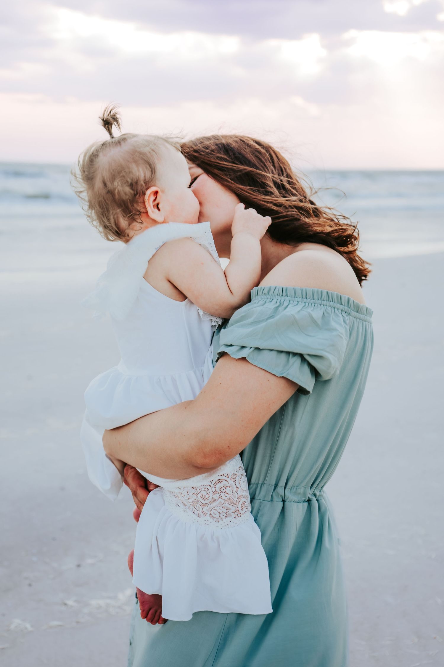 Outdoor Family Session at Indian Rocks Beach in Indian Rocks, FL; Mom kissing baby on beach