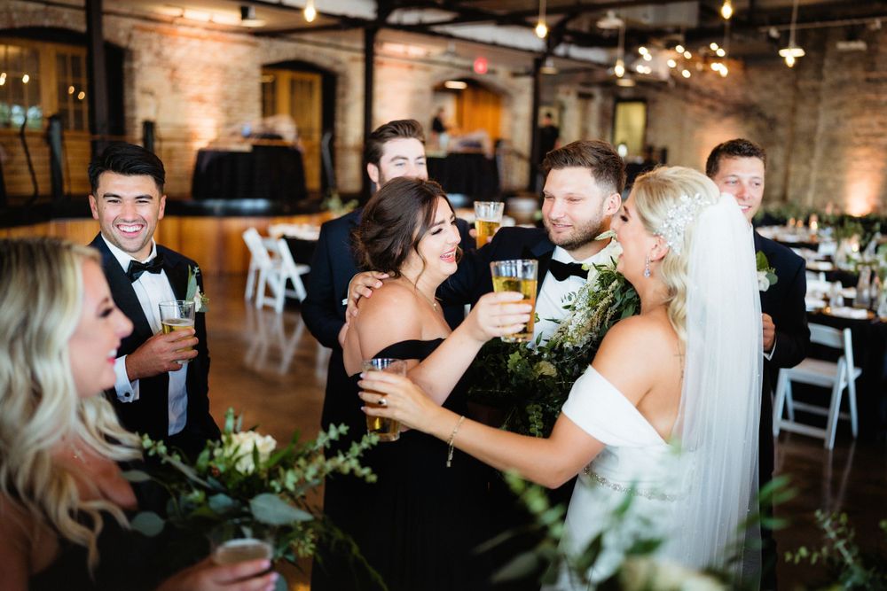Wedding celebration toasts in industrial venue with exposed brick and mood lighting.