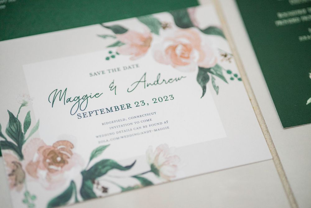 Wedding invitation with watercolor floral design in peach and green tones.