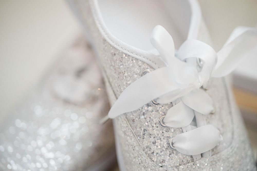 Close-up of a white lace baby shoe with ribbon laces.
