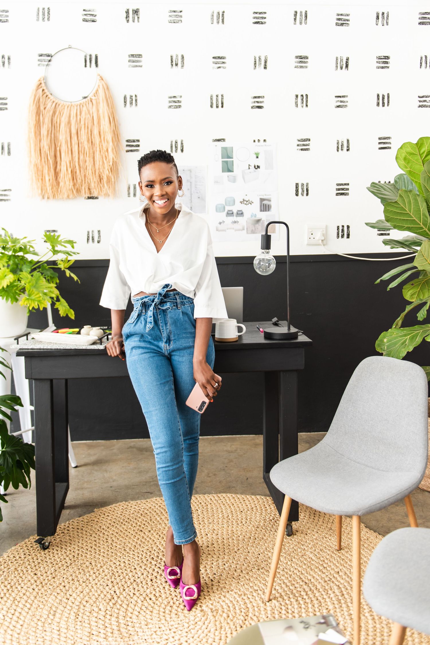 Stylish office space features modern decor with jeans-clad person standing by desk.