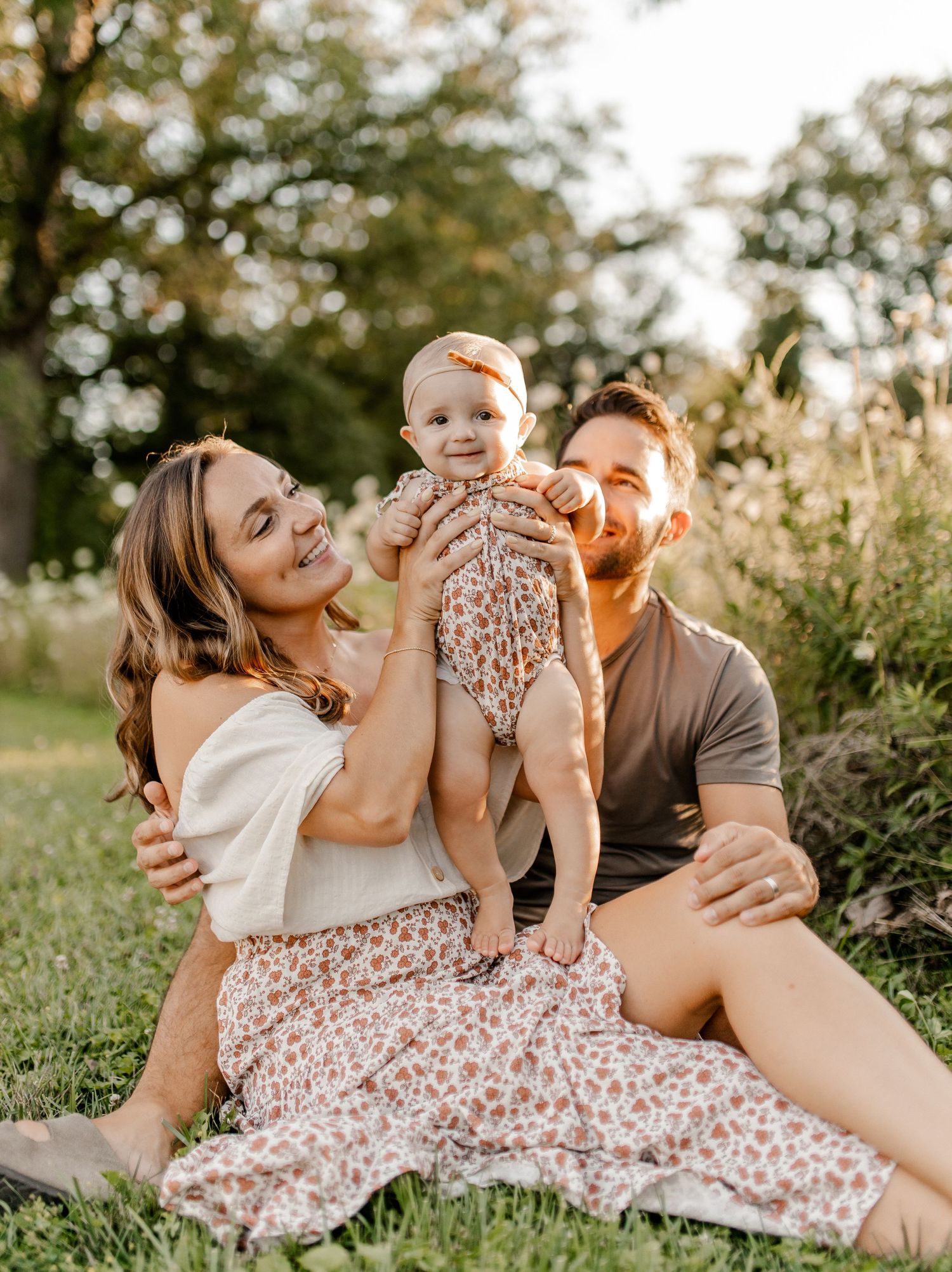 Happy family moment captured outdoors in flowering field during golden hour.