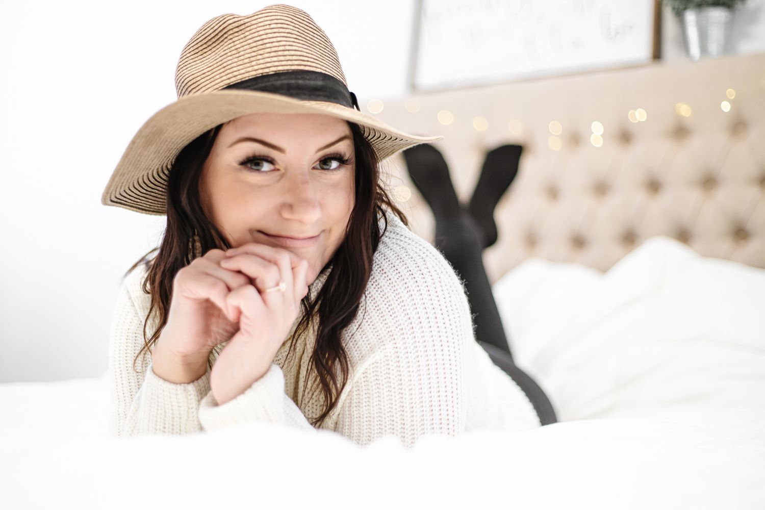 Winter portrait photoshoot featuring a cream knit sweater and wide brim hat in the snow.