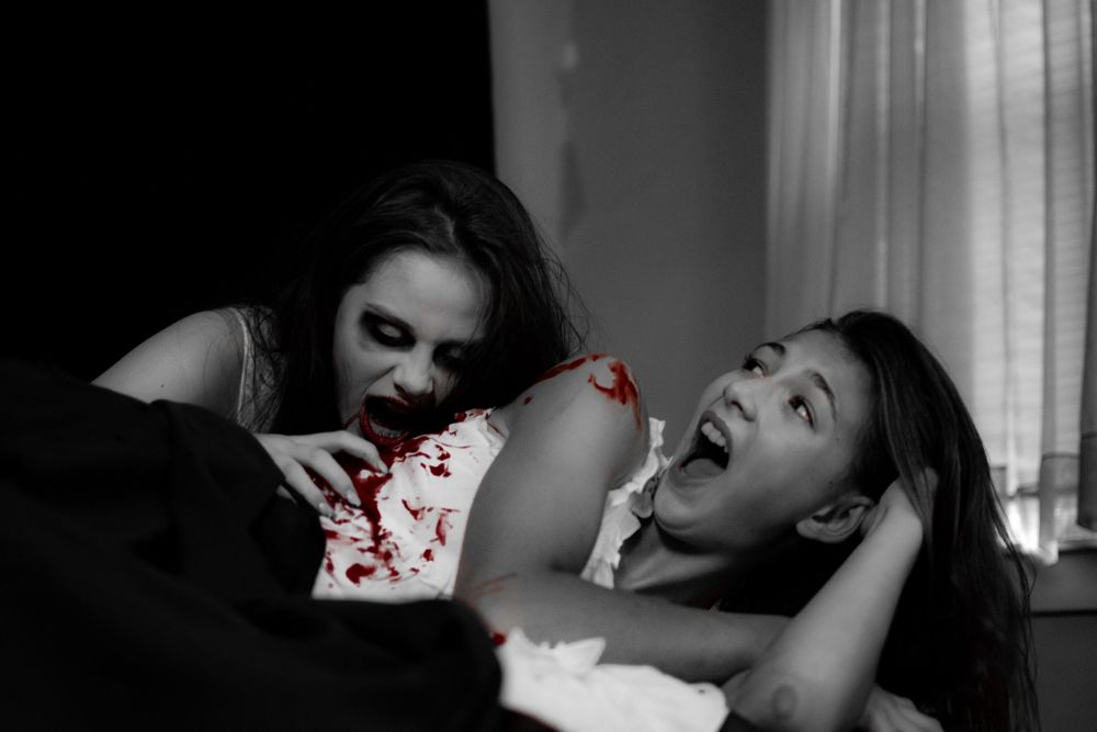 Dramatic black and white boudoir photo with selective red coloring.