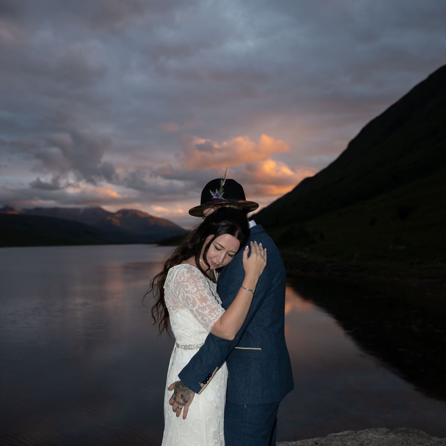 Intimate dance moment captured against moody mountain lake sunset.