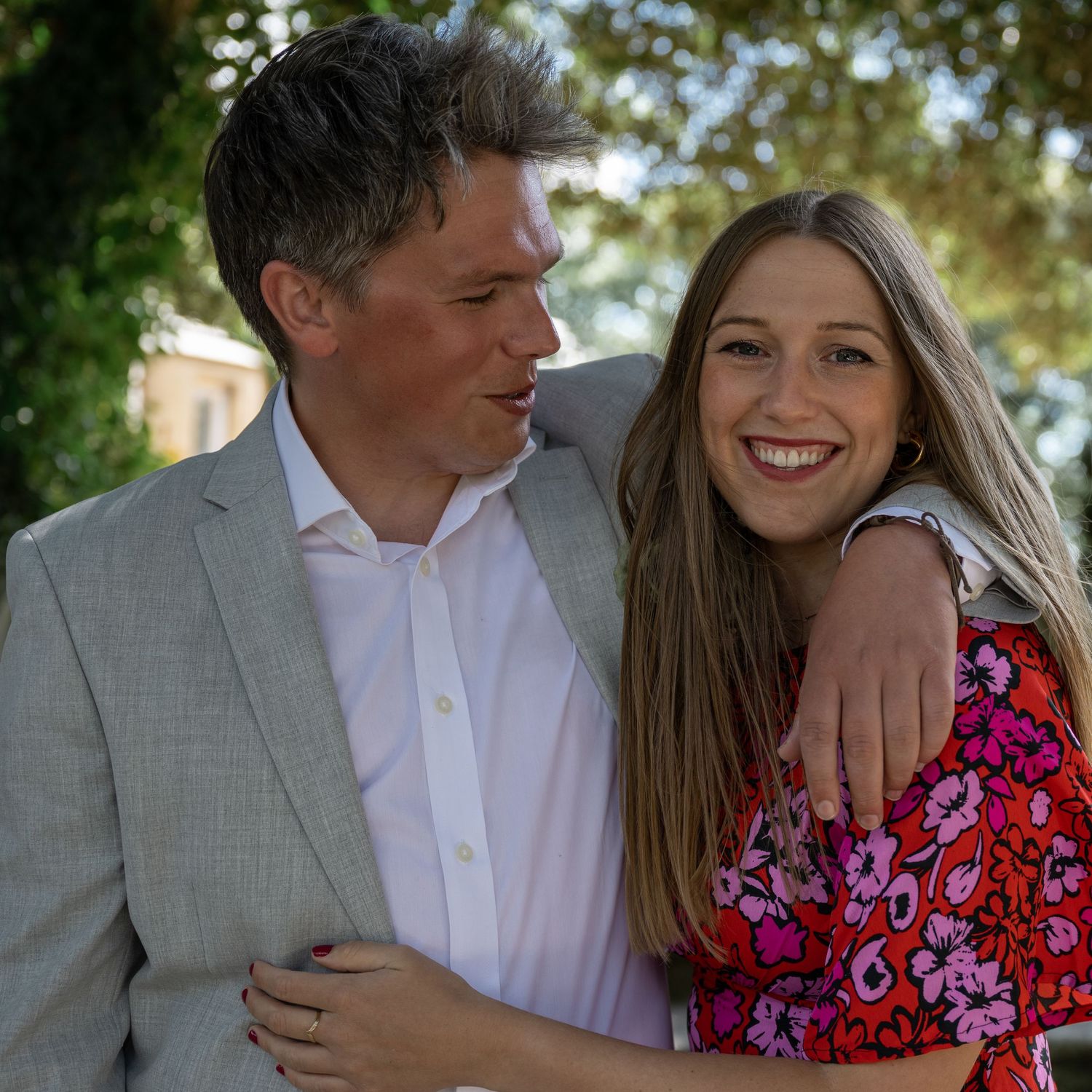 A joyful casual portrait captured in a sunny garden setting.