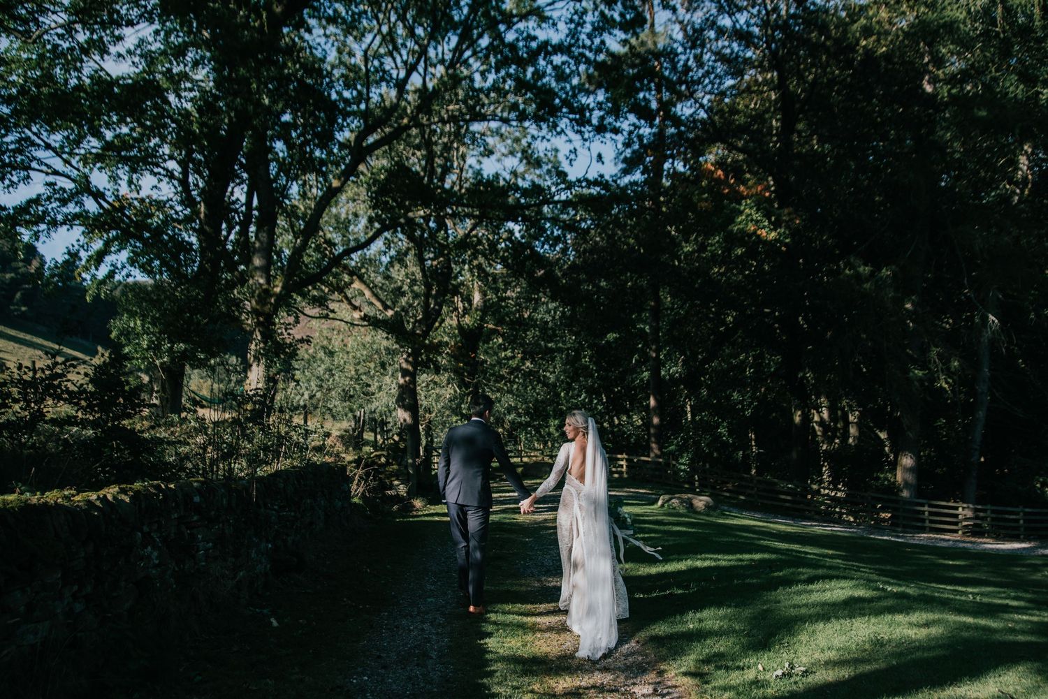 A peaceful garden pathway surrounded by lush trees and manicured lawns.