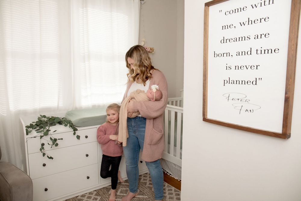 Mother and child sharing a tender moment in a nursery with inspirational wall art.