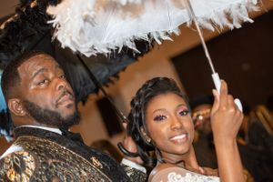 A celebratory moment under white feathers during a wedding reception.