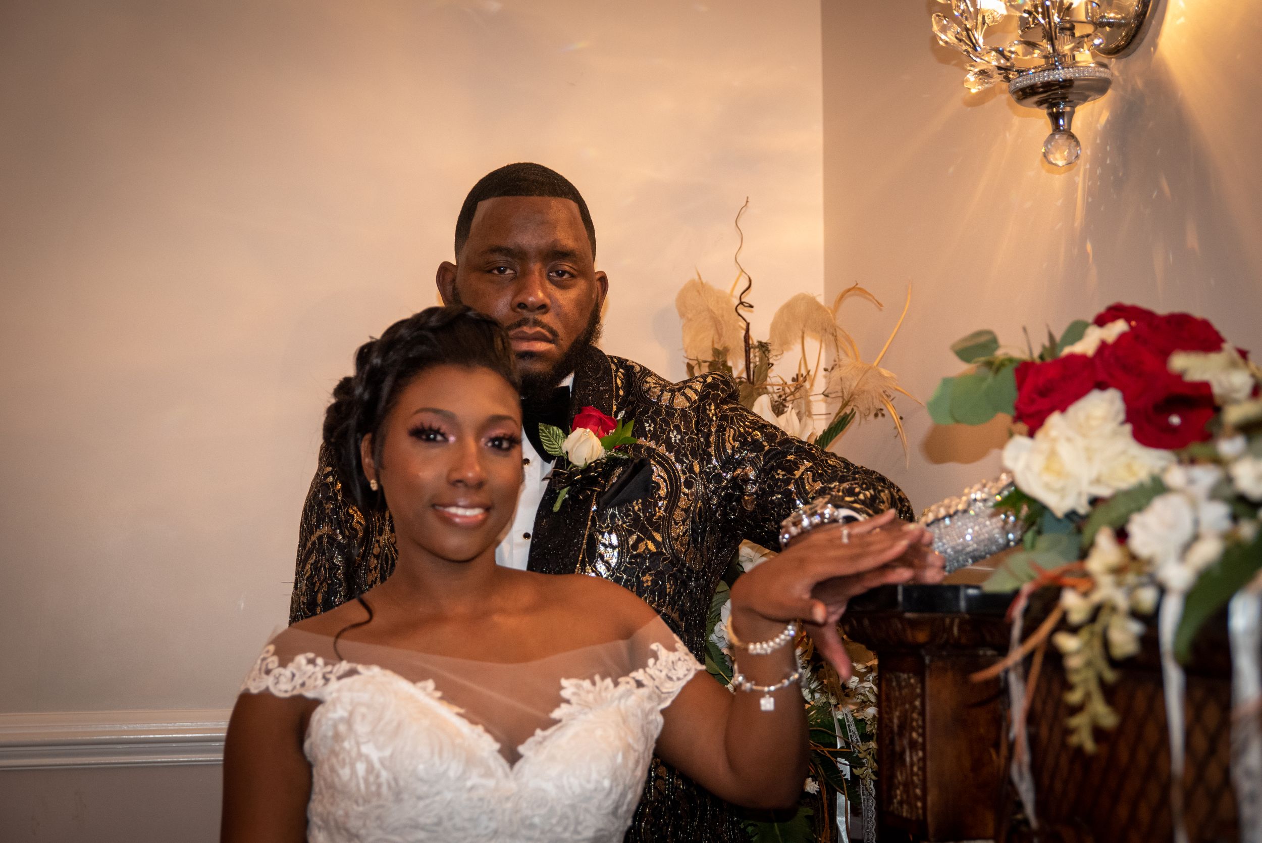 A joyful wedding moment captured under elegant lighting and floral decorations.
