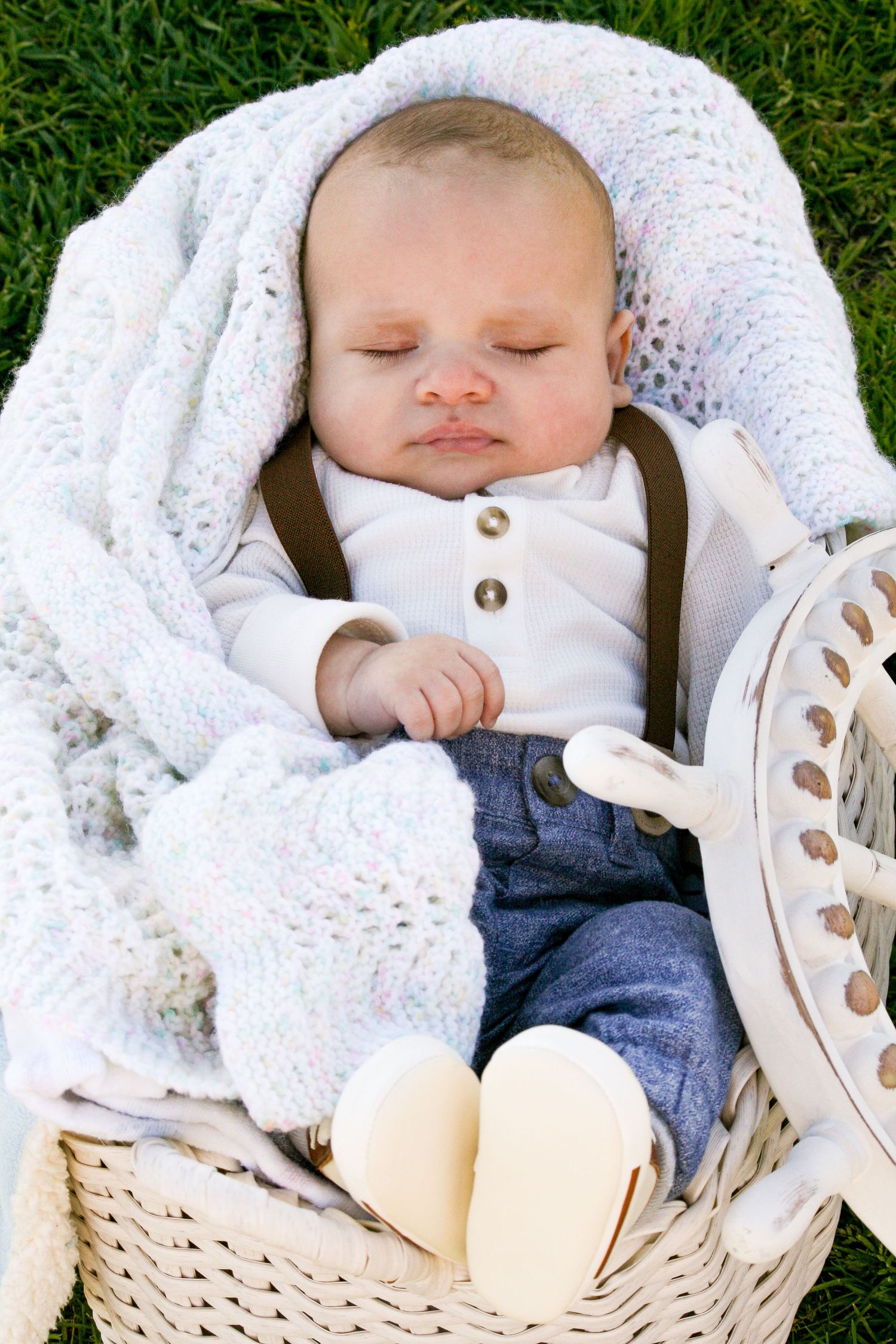 sleeping baby in basket on the grass