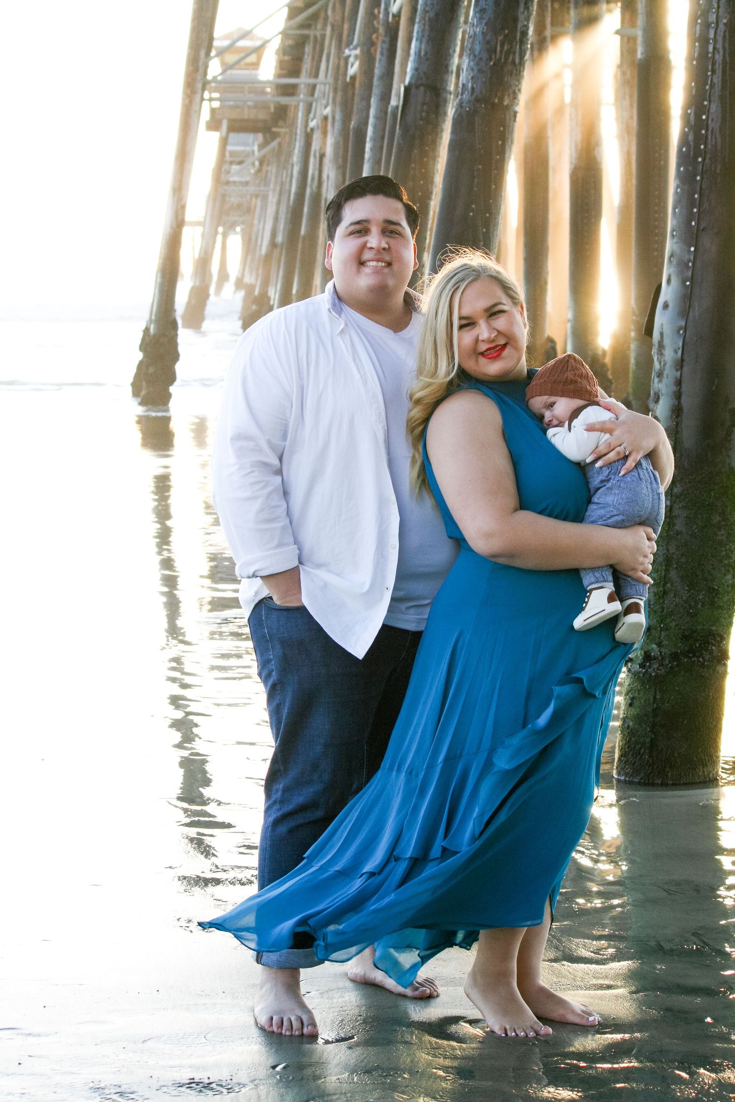 beach family photo at ocean pier during sunset