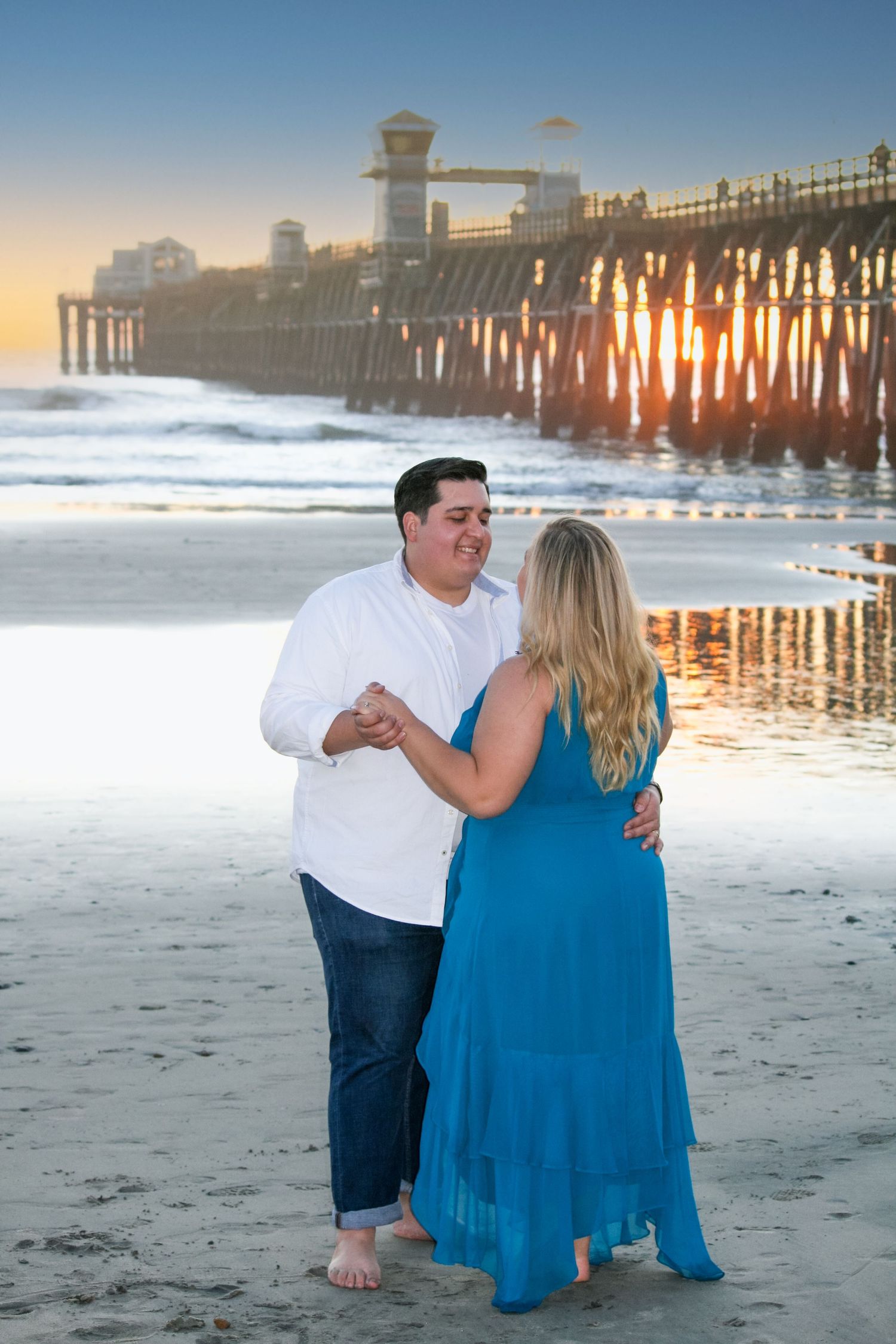 romantic couple dancing on the beach during a sunset