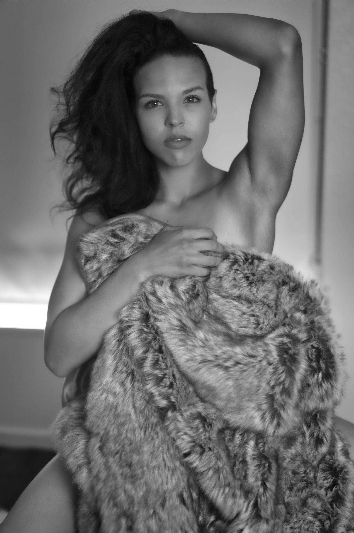 A boudoir photography session featuring intimate poses in a dimly lit living setting.