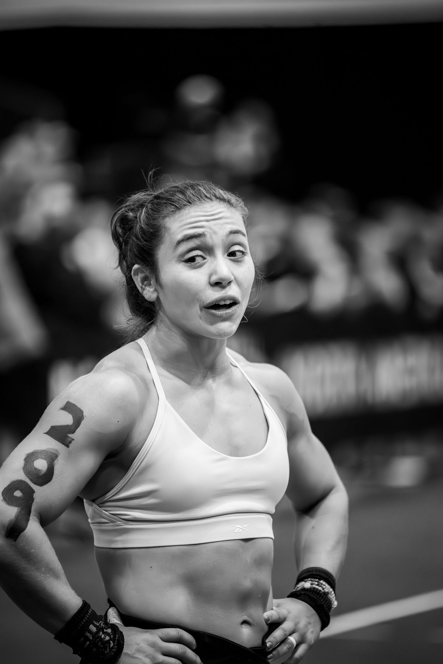 Athlete with number tattoo looking focused during CrossFit competition.