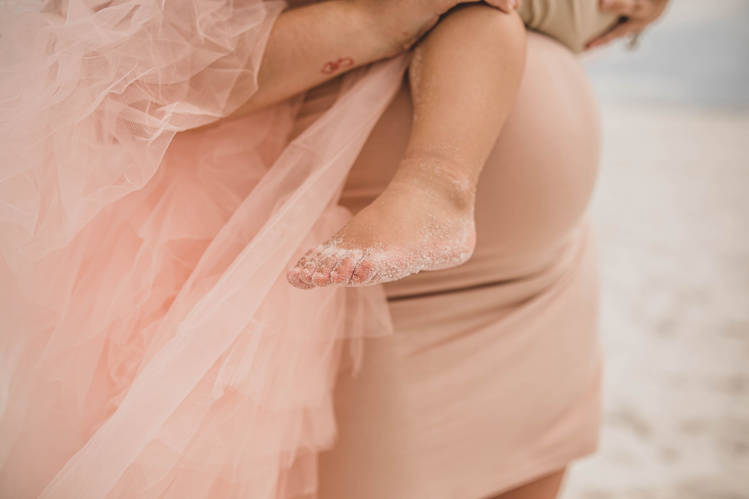 Close up details of a pink tulle dress in soft natural lighting.