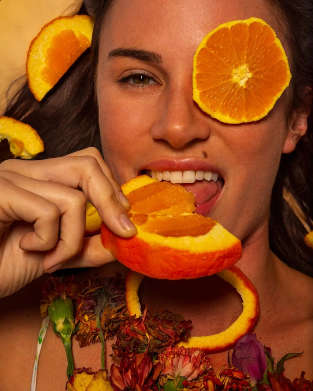 Natural makeup model with oranges and flowers, natural makeup, artistic fashion.
