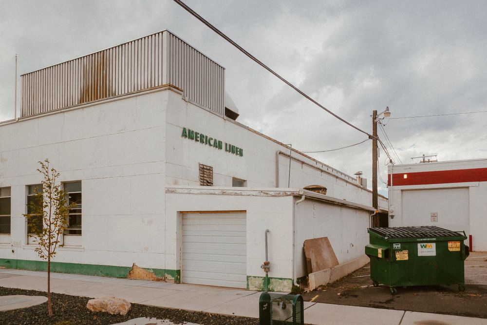 White commercial building exterior with American Linen signage and loading dock.