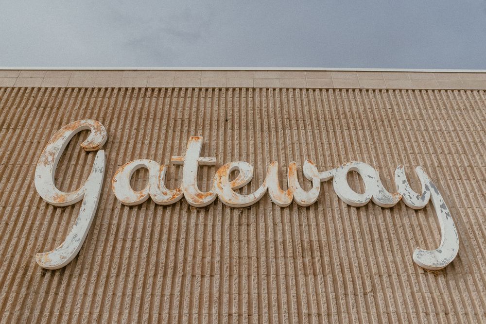 Large retro 'Gateway' text sign mounted on a corrugated wall.