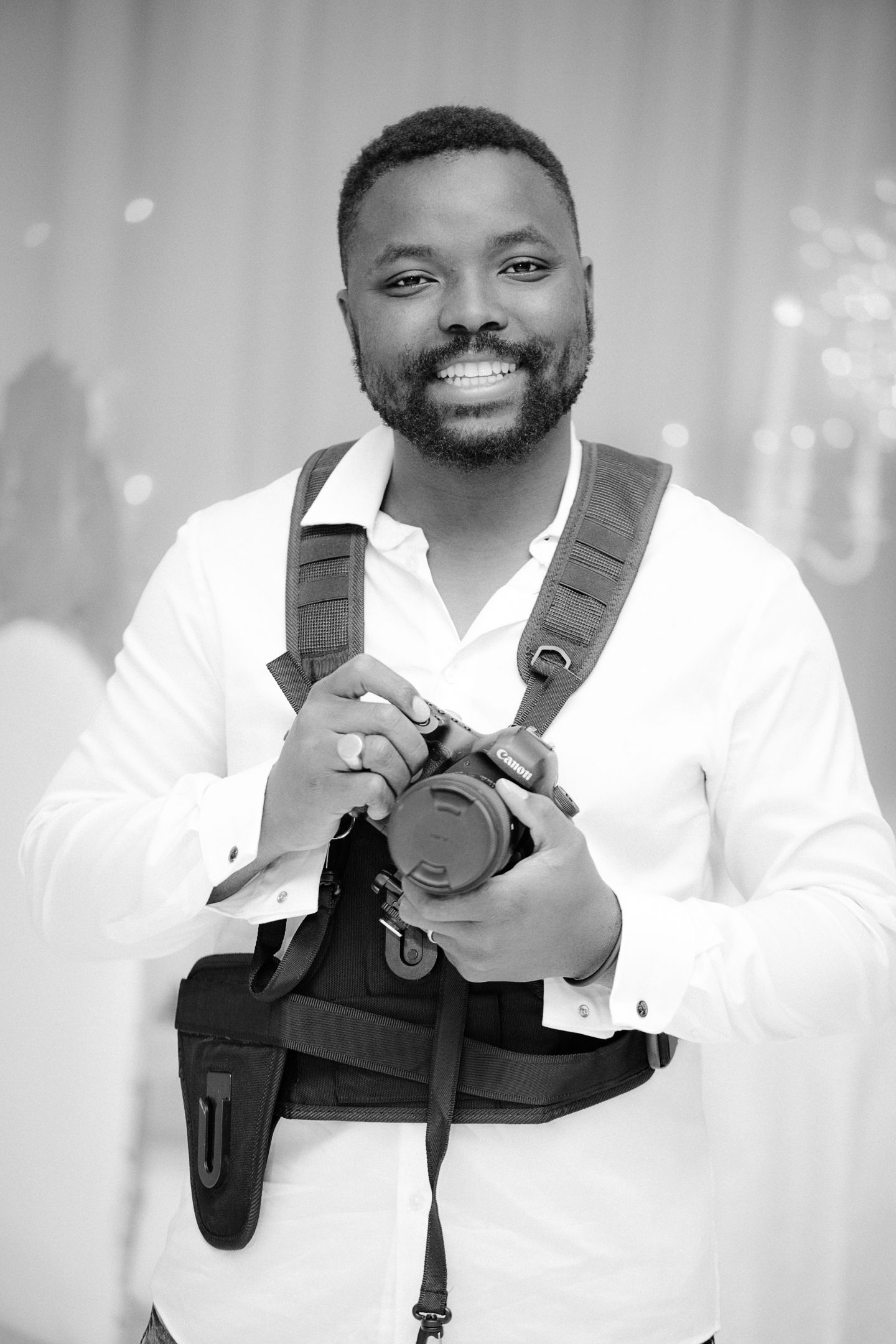 A smiling person in a white dress shirt poses with camera equipment in a series of professional headshots.