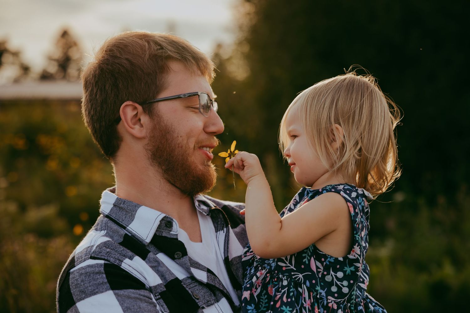 Sweet moment between parent and toddler sharing food outdoors at sunset.