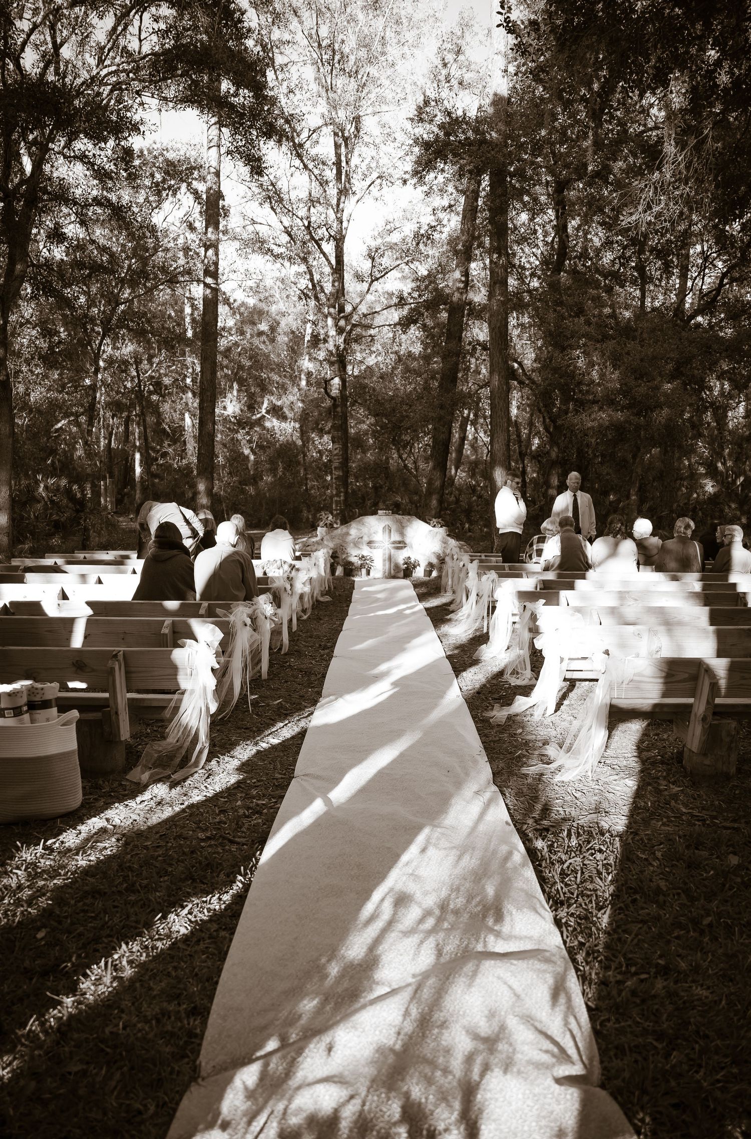 Black and white artistic wedding photo showing ethereal movement through a wooded cemetery.