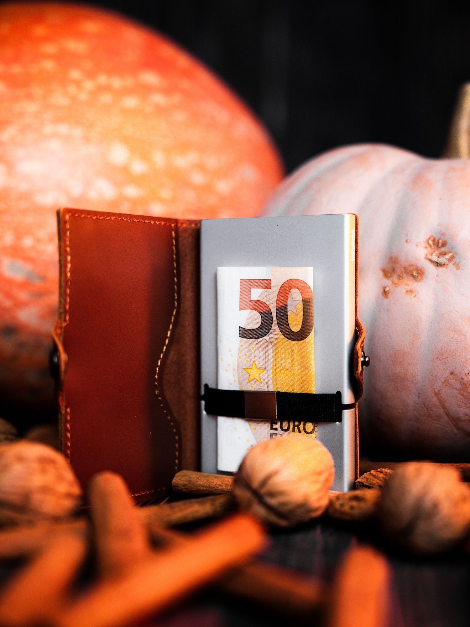Close-up of leather wallet with Euro banknotes in warm lighting.