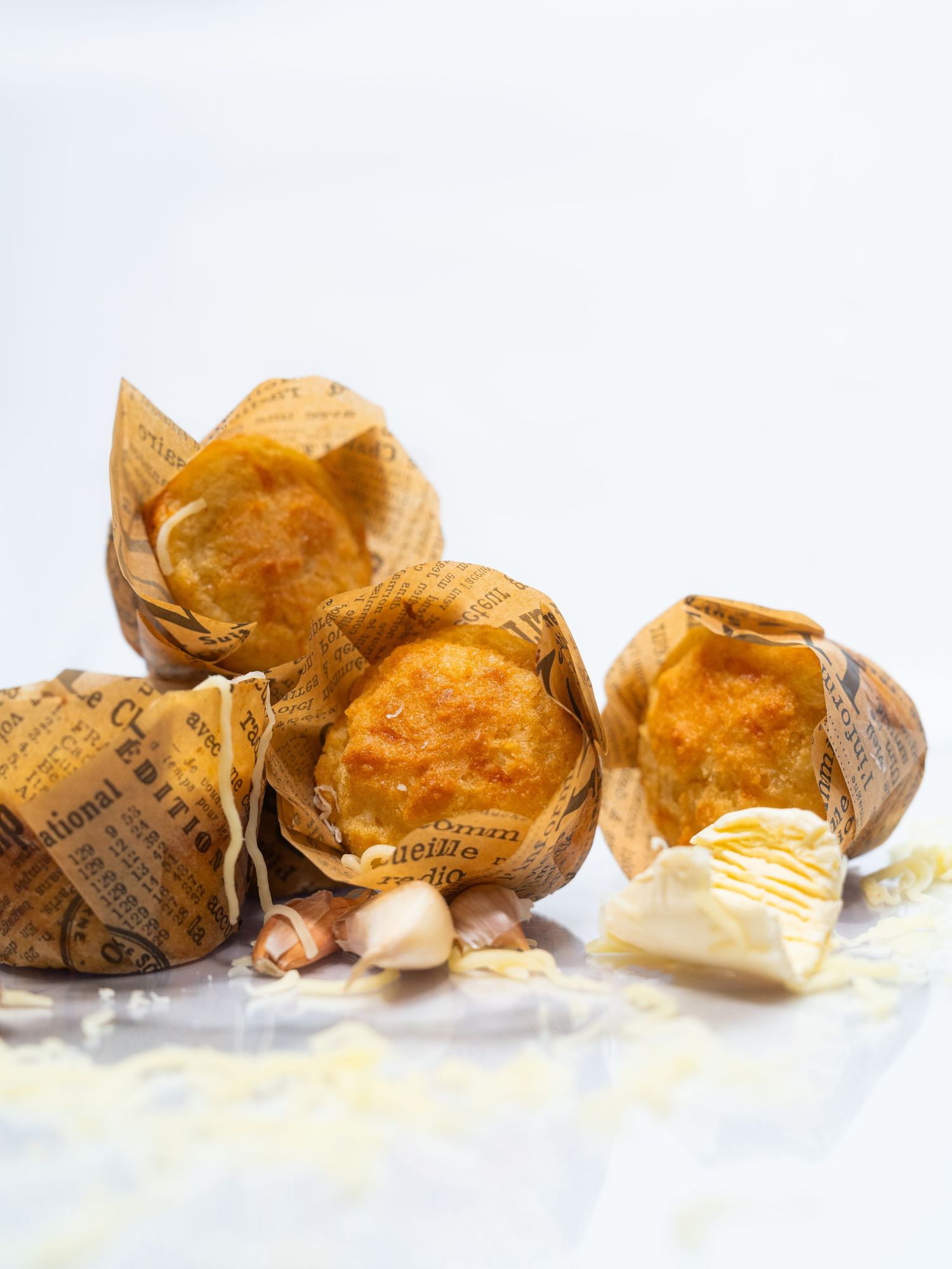 Fresh baked muffins wrapped in brown paper with butter on the side.