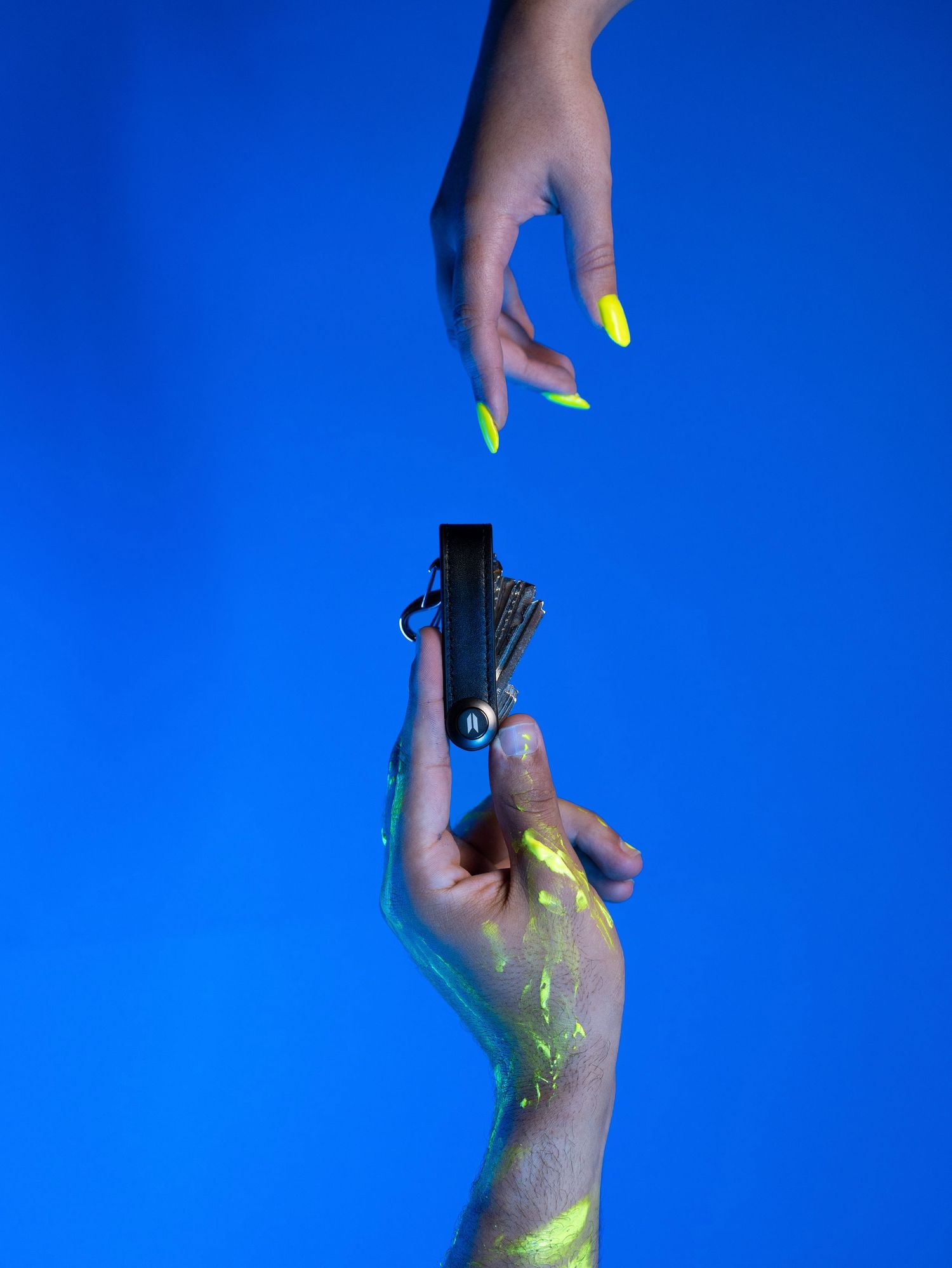 Hands manipulating slime or gel against a bright blue background.