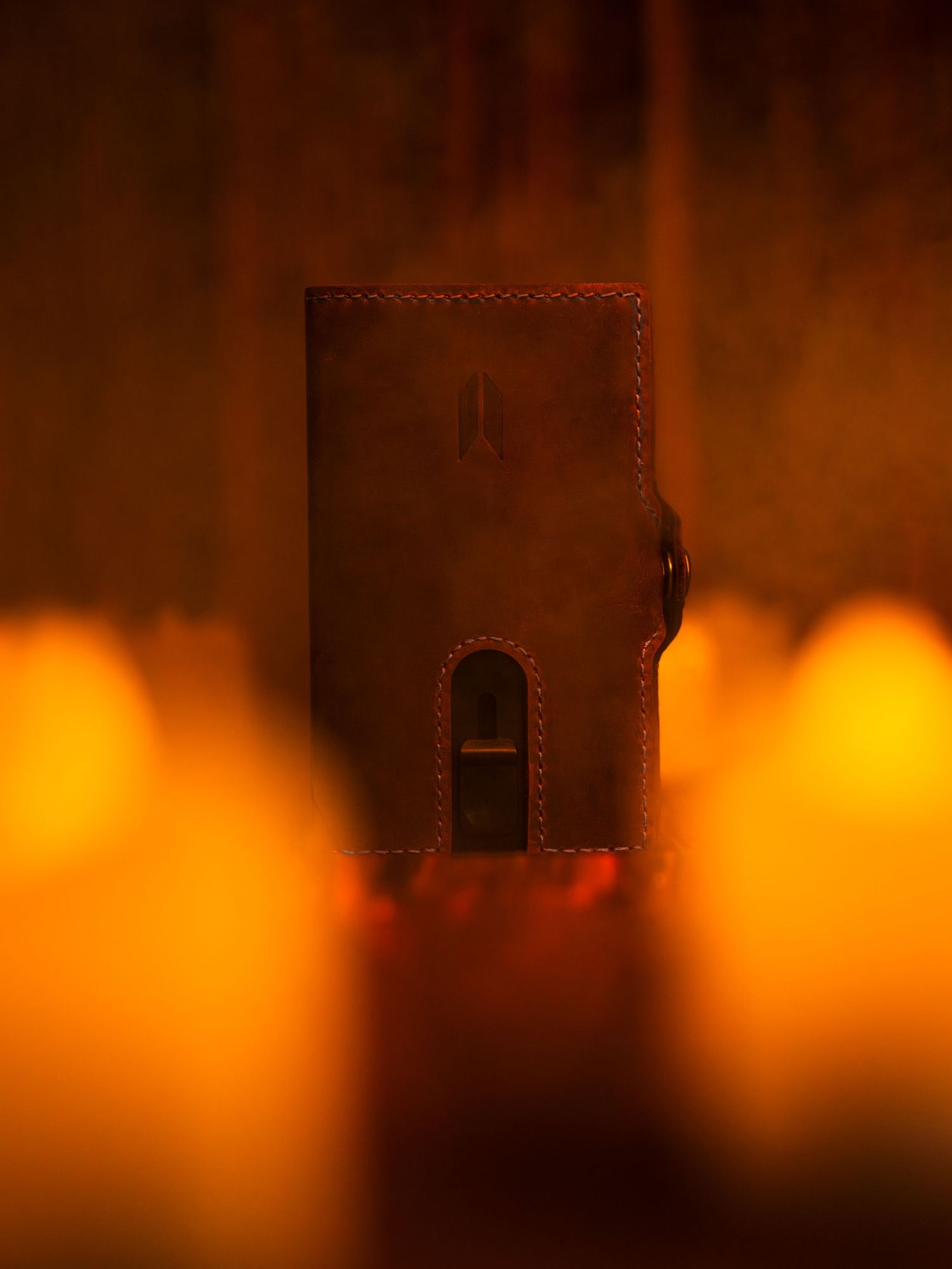 Leather wallet silhouette against warm orange atmospheric lighting.