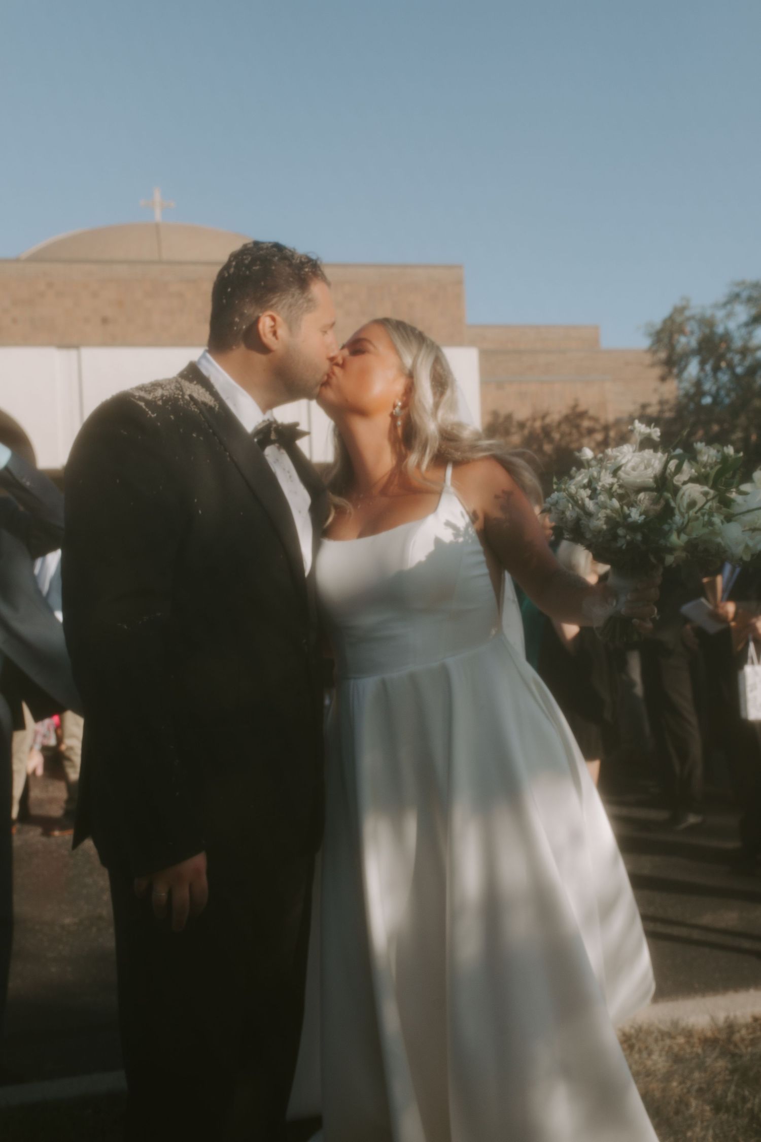 Elegant couple in formal attire share an intimate moment at their outdoor wedding ceremony.