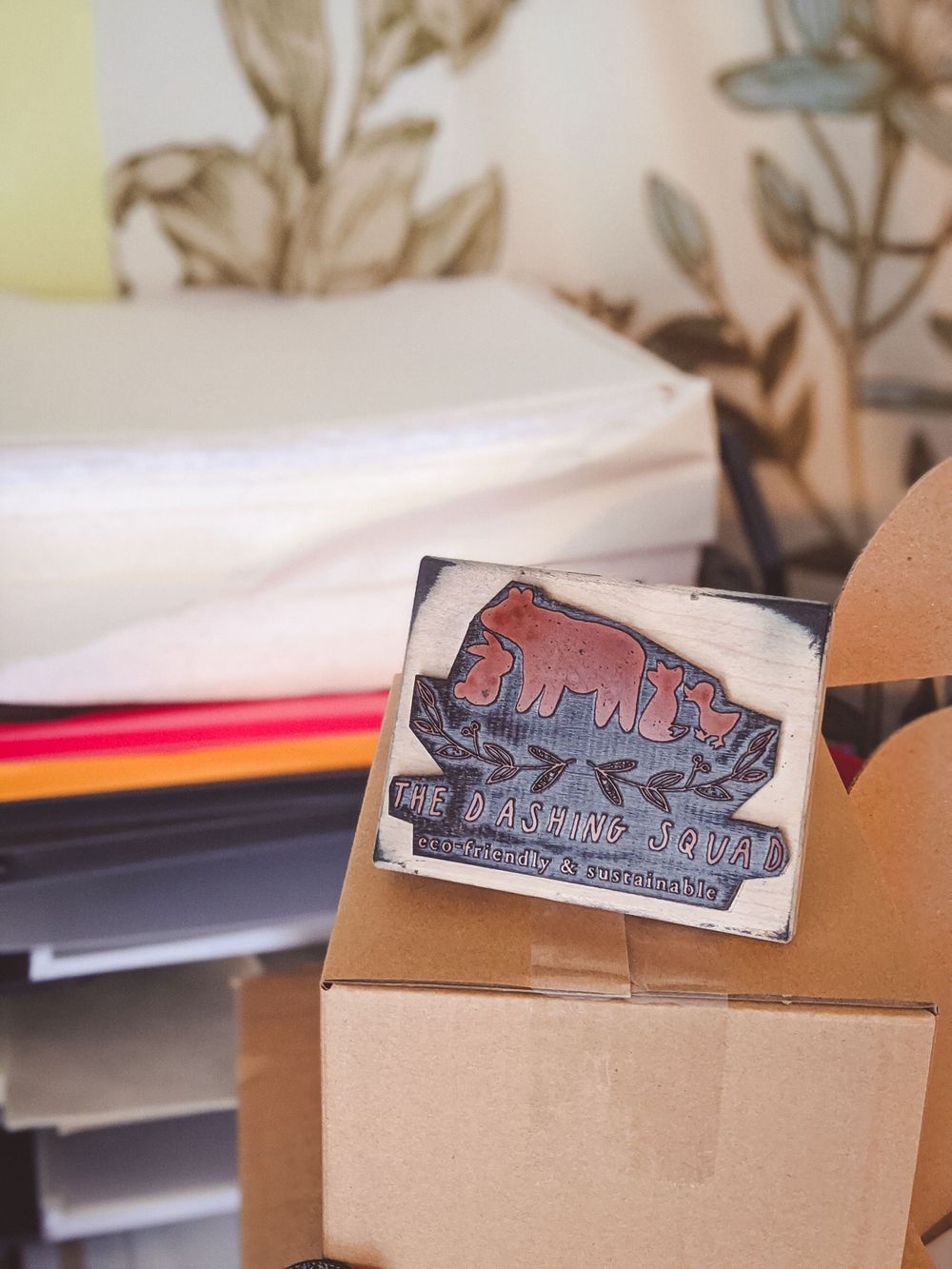 Vintage wooden printing block with bear design for The Dancing Bear brand on cardboard box.